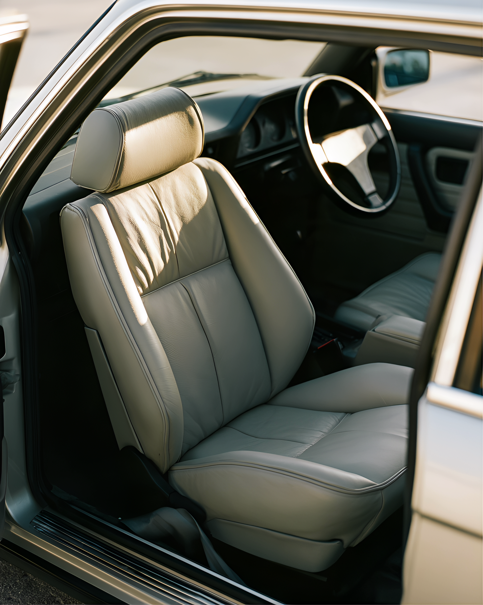 Open car door framing a grey leather seat